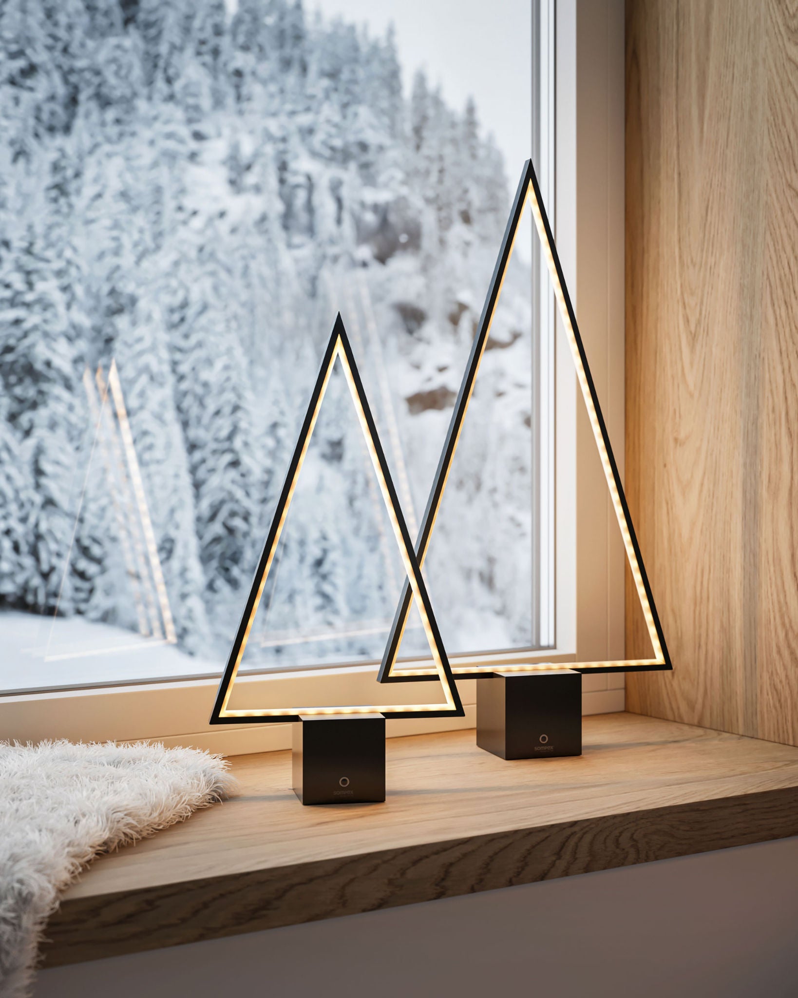 Zwei Pine LED Tischleuchten von Sompex in Sternform auf der Fensterbank im winterlich dekorierten Wohnzimmer