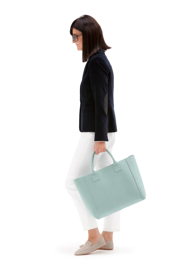 Frau mit Hey-Sign Filztasche Pure mit gleichfarbigen Henkeln in unifarbenem Wollfilz, Farbe Aqua